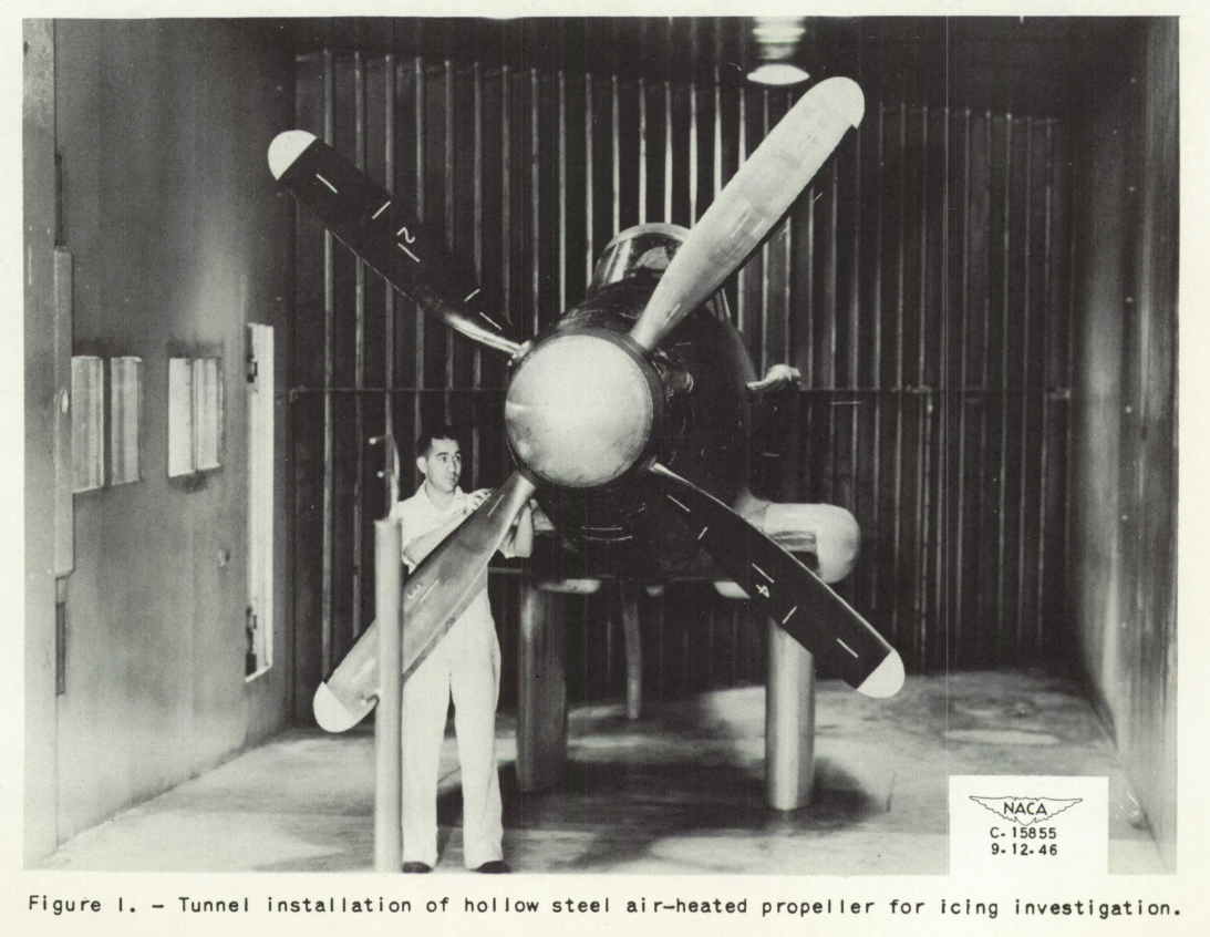 Figure 1. Tunnel installation of hollow steel air-heated propeller for icing investigation. A tall, lean man with a distinctively tall nose inspects the propeller.