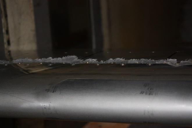 An airfoil of aluminium construction with a heated leading edge. Aft of rivets, which mark the approximate limit of the heating, runback ice forms as lumps and streaks.